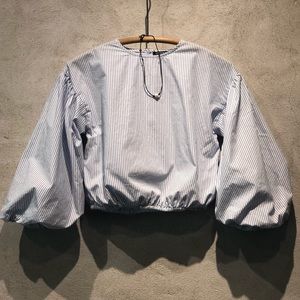 Child’s white and blue pin striped blouse.